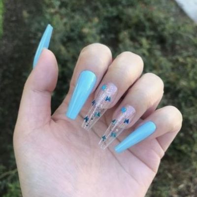 The fingers, with long nails, are adorned with beautifully painted blue butterflies