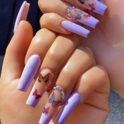The hand of a person is painted with a layer of lilac polish, embellished with unique butterfly stickers