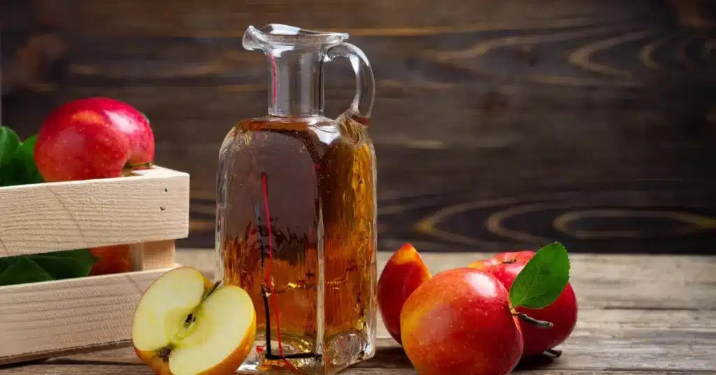 Apple Cider Vinegar in a glass container and fresh apples